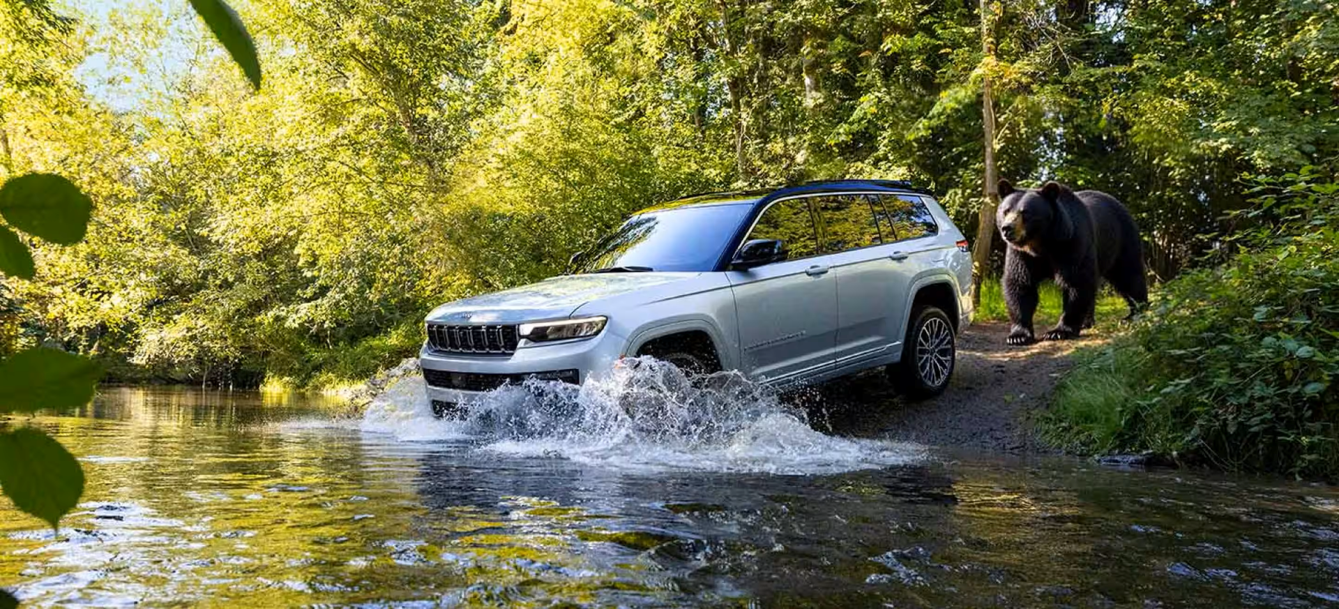 2026 Jeep Grand Cherokee fording water in the forest