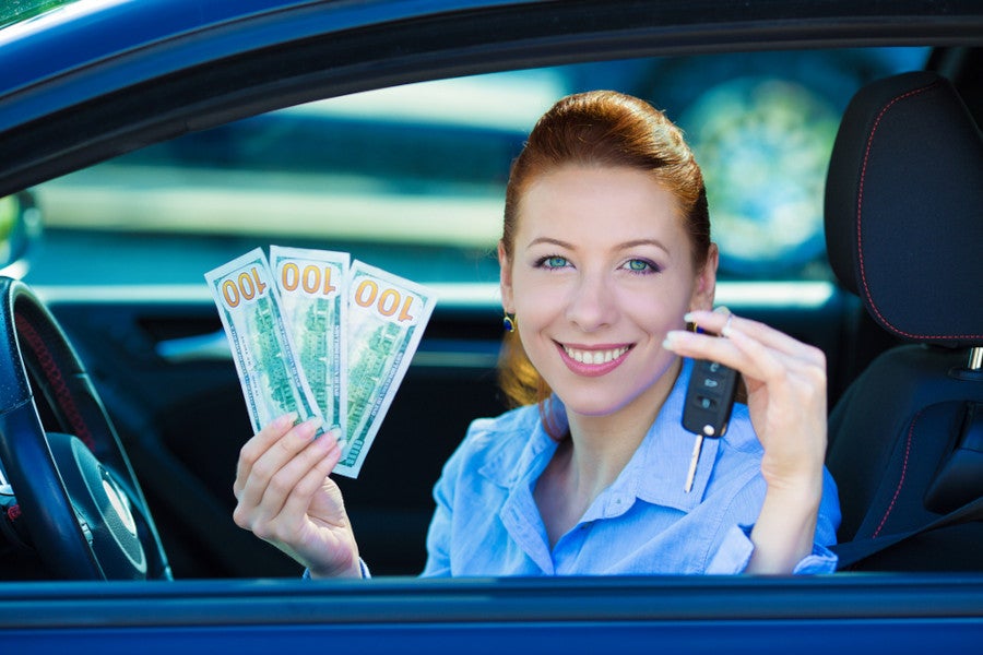 A women showing cash and key from window of car